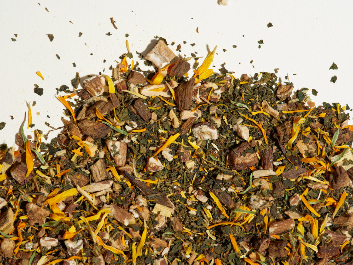 Glow tea loose leaf tea leaves on a flat surface.