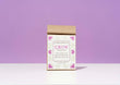 A kraft paper bag of Harbor Herbalist 'Grow' Prenatal Tea, featuring a white front label with pink floral illustrations, set against a solid lavender background on a white surface.
