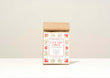 A kraft paper bag of Harbor Herbalist Lift The Grey Loose Leaf Tea, featuring a white label with red and gold botanical illustrations, set against a plain off-white background.