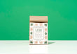 A bag of Harbor Herbalist Lush loose leaf tea, featuring a white label decorated with green and gold botanical illustrations, stands upright on a white surface against a bright green background.