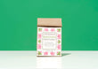 A bag of Harbor Herbalist Rasayana Mindful Tea Blend, featuring a kraft paper top and a white front label with pink and green botanical illustrations, set against a solid green background.