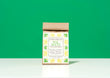 A kraft paper bag of Harbor Herbalist Sol Mate Yerba Mate blend tea with a white label with yellow and green botanical illustrations, set against a solid green background on a white surface.